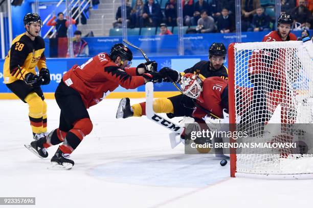 Germany's Yasin Ehliz and Canada's Kevin Poulin look at the puck in the men's semi-final ice hockey match between Canada and Germany during the...