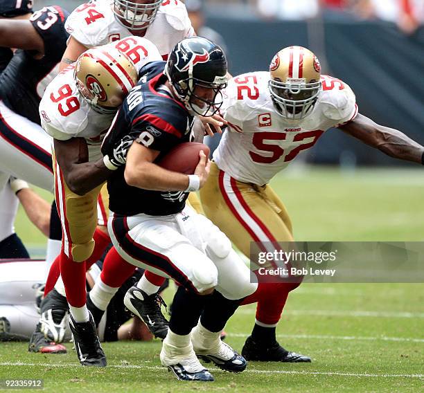 Quarterback Matt Schaub of the Houston Texans is sacked by linebacker Manny Lawson of the San Francisco 49ers as Patrick Willis looks on at Reliant...