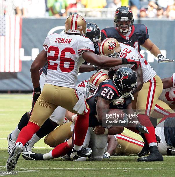 Running back Steve Slaton of the Houston Texans is tackled by linebacker Patrick Willis and Mark Roman of the San Francisco 49ers at Reliant Stadium...
