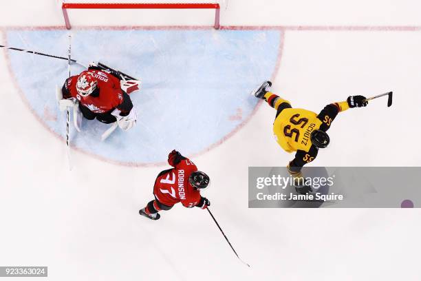 Felix Schutz of Germany celebrates a goal by Patrick Hager in the second period as Kevin Poulin of Canada reacts during the Men's Play-offs...