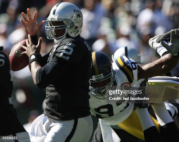 JaMarcus Russell of the Oakland Raiders fumbles the ball as he is rushed by Calvin Pace of the New York Jets during an NFL game at the...