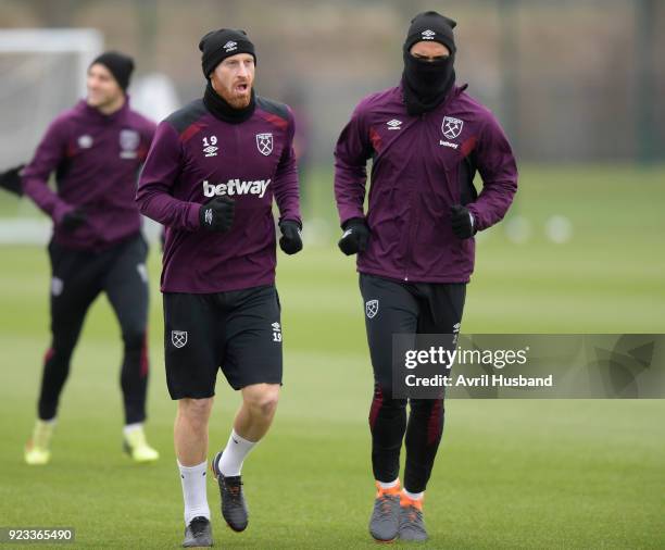 James Collins and Winston Reid of West Ham United wrap up warmly against the bitter wind prior to training at Rush Green on February 23, 2018 in...