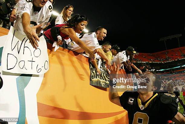 Quarterback Drew Brees of the New Orleans Saints celebrates with Saints' fans after his team's victory over the Miami Dolphins at Land Shark Stadium...
