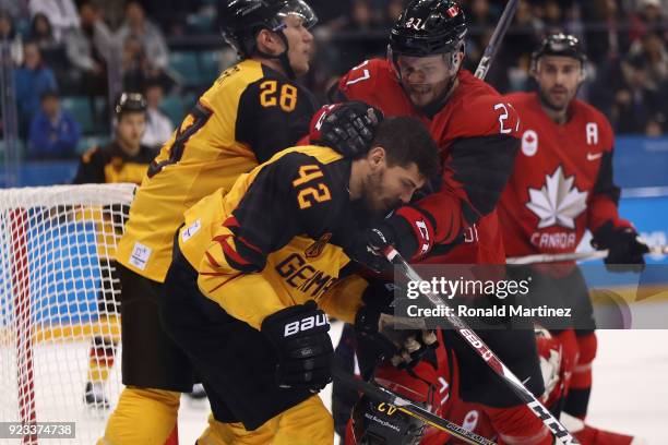 Cody Goloubef of Canada collides with Yasin Ehliz of Germany in the third period during the Men's Play-offs Semifinals on day fourteen of the...