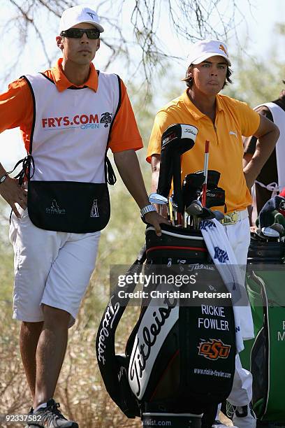 Rickie Fowler stands with his caddie Joe Skovron on the third hole tee box during the fourth round of the Frys.com Open at Grayhawk Golf Club on...