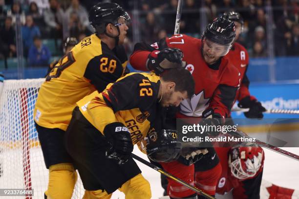 Cody Goloubef of Canada collides with Yasin Ehliz of Germany in the third period during the Men's Play-offs Semifinals on day fourteen of the...