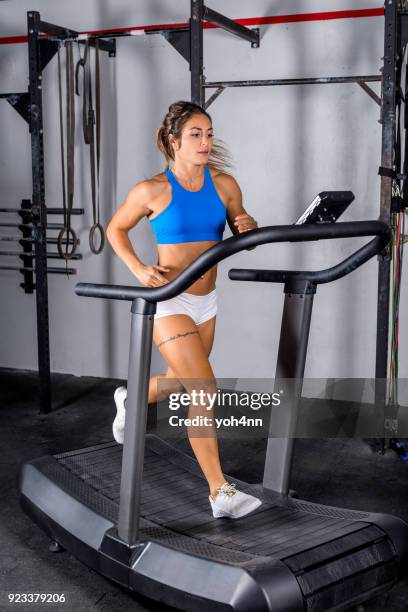 mujer que corre en una caminadora en el gimnasio - treadmill fotografías e imágenes de stock