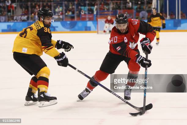 Maxim Lapierre of Canada controls the puck against Yannic Seidenberg of Germany during the Men's Play-offs Semifinals on day fourteen of the...