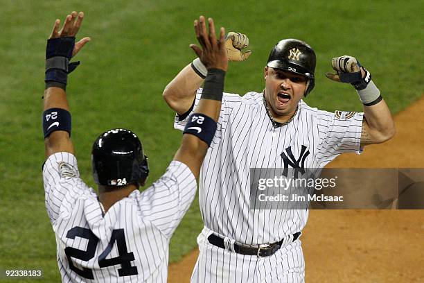 Nick Swisher of the New York Yankees and Robinson Cano celebrate scoring off a single by Johnny Damon in the bottom of the fourth inning against the...