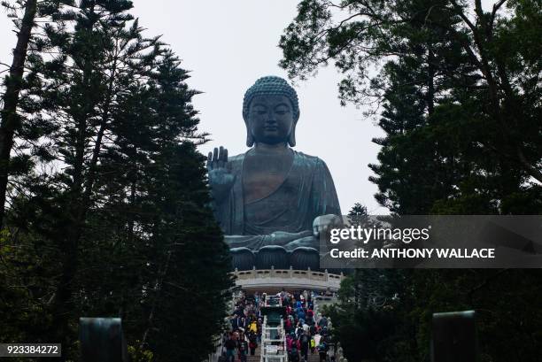 Visitors use a stairway that leads to the Big Buddha on Hong Kong's outlying Lantau Island on February 23, 2018. / AFP PHOTO / ANTHONY WALLACE