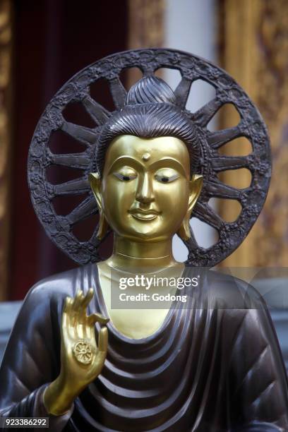 Buddha and wheel of dharma statue in a Chiang Mai temple. The Buddha's first lecture. Thailand.