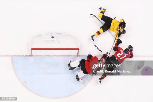 Kevin Poulin and Cody Goloubef of Canada defend against Dominik Kahun of Germany in the third period during the Men's Play-offs Semifinals on day...