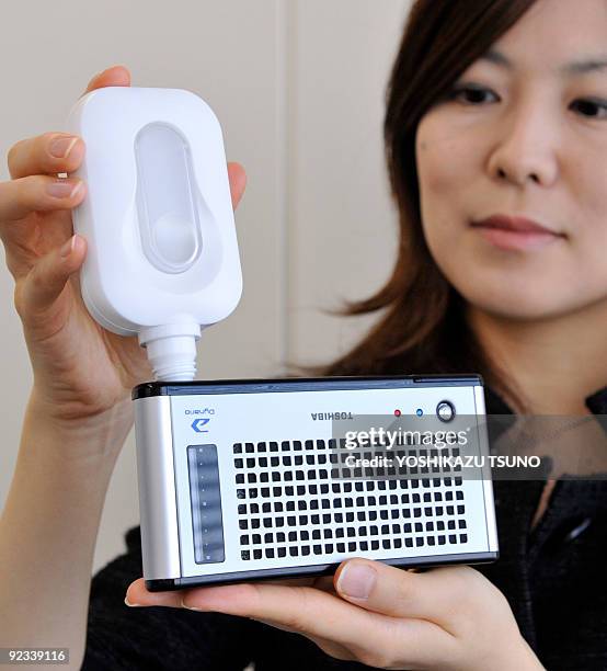 Japanese electronics giant Toshiba employee displays the handheld electronic gadget, a direct methanol fuel cell battery "Dynario" for the external...