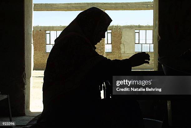 Women worker sorts raisens July 8, 2002 at the Amir Raisin Factory in Kabul, Afghanistan. The factory was destroyed and looted during Afghanistan's...