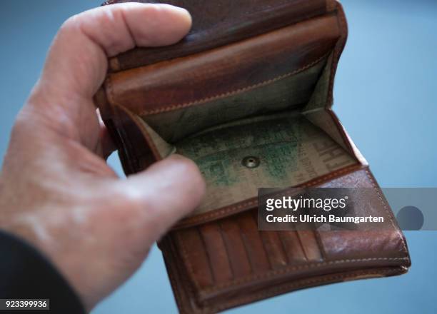 Symbolic photo on the topics poverty, old age poverty, bankrupt, pensioner poverty, broke, etc. The picture shows a hand with an empty money purse.