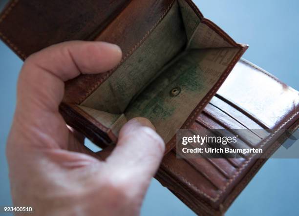 Symbolic photo on the topics poverty, old age poverty, bankrupt, pensioner poverty, broke, etc. The picture shows a hand with an empty money purse.