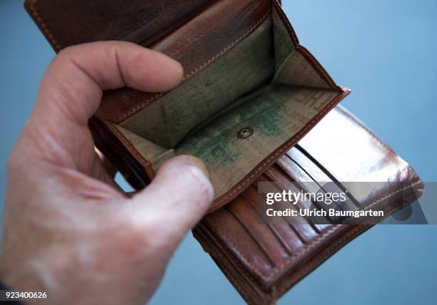 Symbolic photo on the topics poverty, old age poverty, bankrupt, pensioner poverty, broke, etc. The picture shows a hand with an empty money purse.