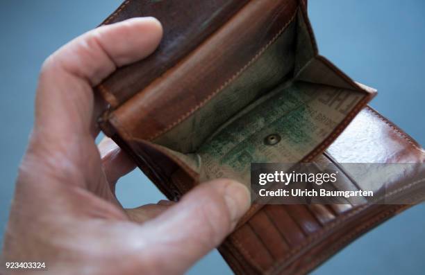 Symbolic photo on the topics poverty, old age poverty, bankrupt, pensioner poverty, broke, etc. The picture shows a hand with an empty money purse.