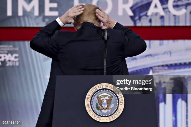 President Donald Trump adjusts his hair while speaking at the Conservative Political Action Conference in National Harbor, Maryland, U.S., on Friday,...