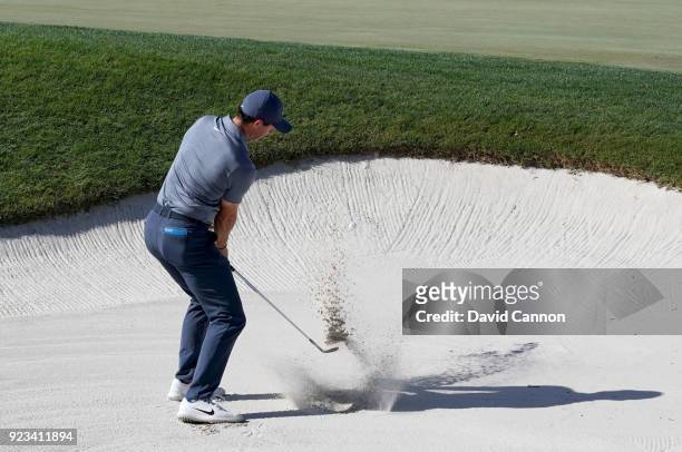 Rory McIlroy of Northern Ireland plays his fourth shot on the par 3, 17th hole from a plugged lie in a bunker just through the green during the...