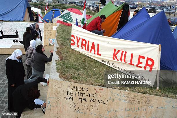 Lebanese women write on a wall where anti-Syrian protesters holding a vigil at the Martyrs Square near the grave of slain former premier Rafiq Hariri...