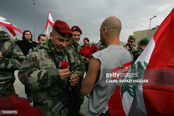 Lebanese pro-opposition protestor distributes roses on Lebanese marine commandos guarding downtown Beirut during an anti-Syria rally 28 February...