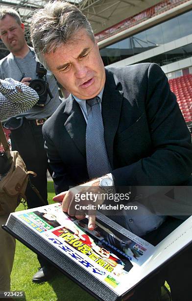Guus Hiddink, former coach of the South Korean soccer team, looks at a book with newspaper clippings about him after he accepted an offer for a...