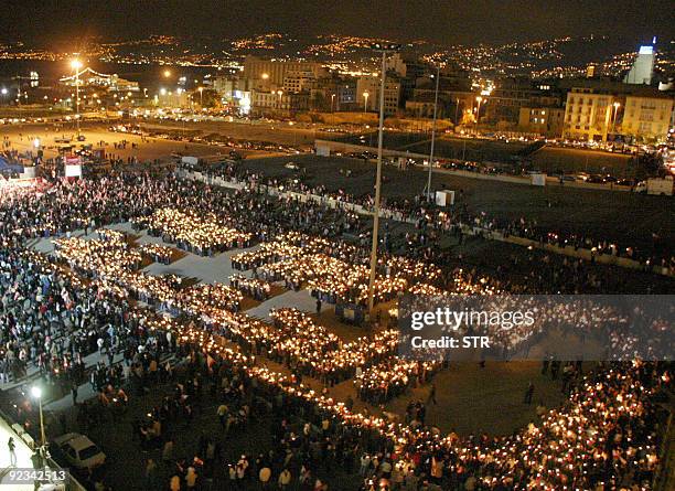 Lebanese hold candles as they form the word "Truth" in downtown Beirut 13 March 2005. Thousands of Lebanese gathered to form with candles the word...