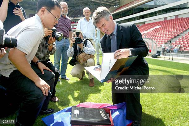 Guus Hiddink, former coach of the South Korean soccer team, looks at a book with newspaper clippings about him after he accepted an offer for a...
