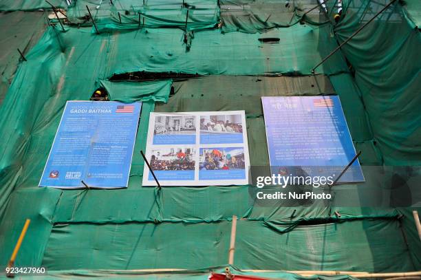 Nepalese workers glancing as Members of Manandhar Guthi erecting ceremonial Bamboo Log known as &quot;Chir&quot; along with the vibrant cloth strips,...