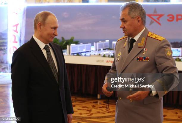 Russian President Vladimir Putin listens to Defence Minister Sergei Shoigu during an awarding ceremony marking the Defender of the Fatherland's Day...