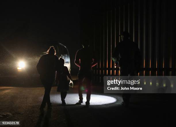 Honduran mother walks with her children next to the U.S.-Mexico border fence as they turned themselves in to Border Patrol agents on February 22,...