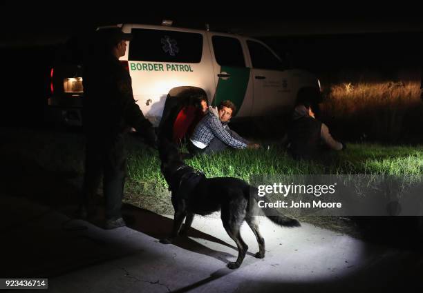 Border Patrol agents watch over undocumented immigrants after pursuing and capturing them with the aid of a K-9 unit on February 22, 2018 near...