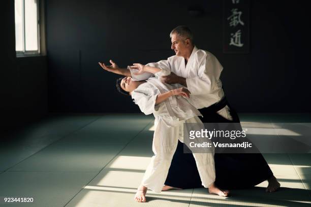 teen boy with his sansei practicing in dojo - akido stock pictures, royalty-free photos & images