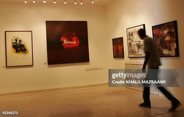 Young man tours an exhibition by Iraqi painters at an art gallery in the Jordanian capital Amman on October 26, 2009. The concerns imposed by the war...