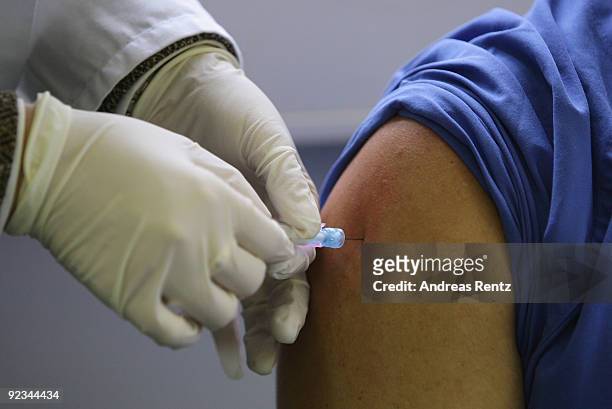 Doctor injects a H1N1 swine flu vaccination in the arm of a nursing service of the Charite at Virchow clinical center, on October 26, 2009 in Berlin,...