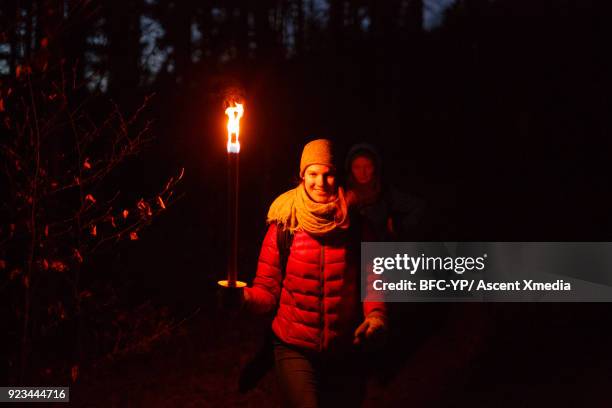 young adults walk along forest path together - fakkel stockfoto's en -beelden