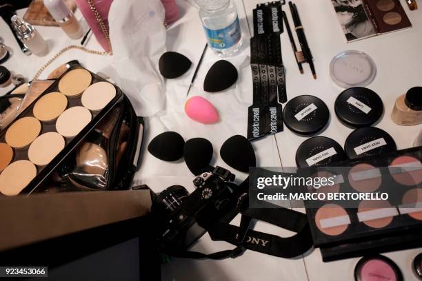 Make up are pictured backstage prior to the women's Fall/Winter 2018/2019 collection fashion show by Roberto Cavalli in Milan, on February 23, 2018....