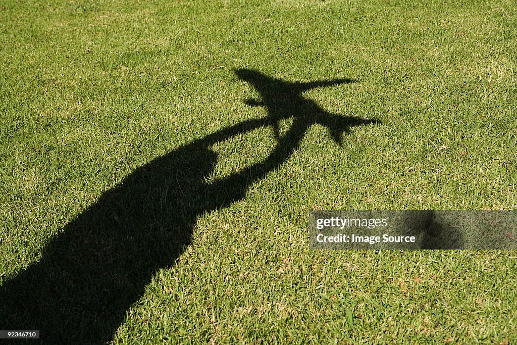 Schatten des Jungen hält bis Spielzeug Flugzeug