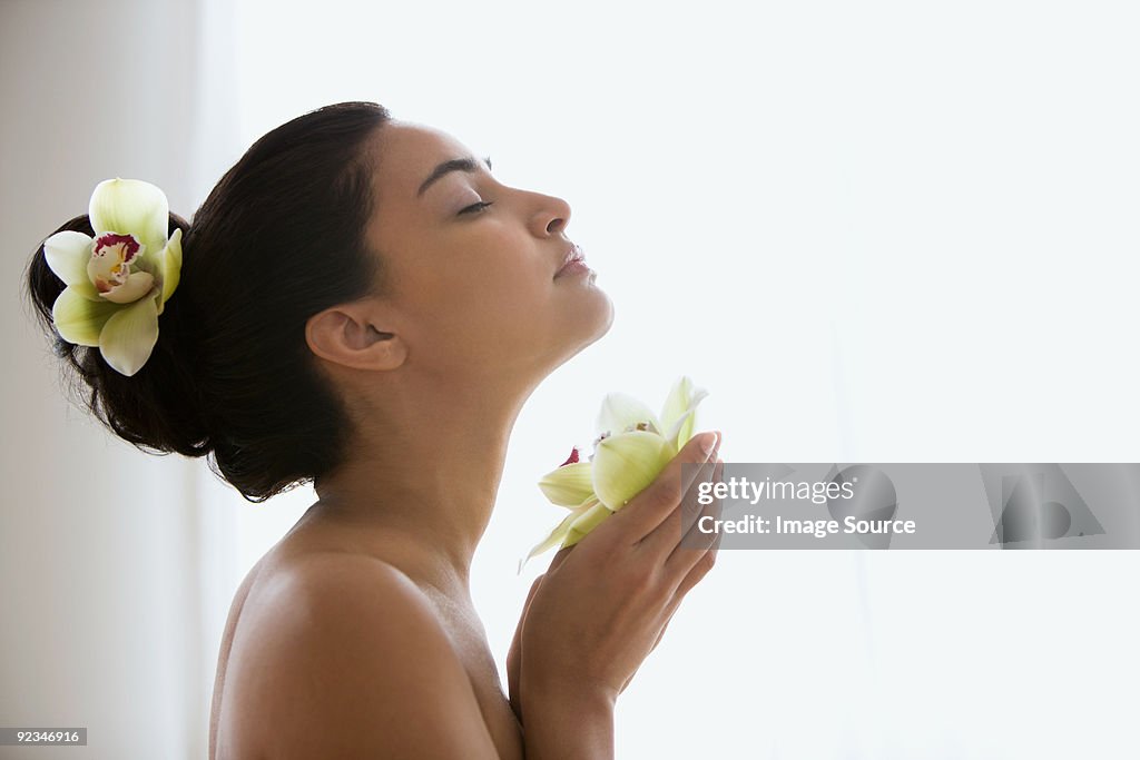 Young woman holding an orchid flower