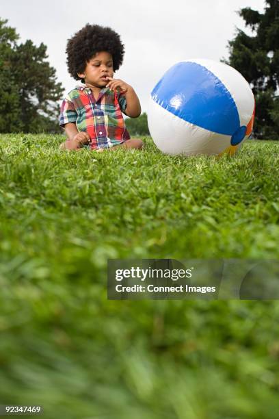baby boy looking at beach ball - boy-sitting-beach-ball stock pictures, royalty-free photos & images