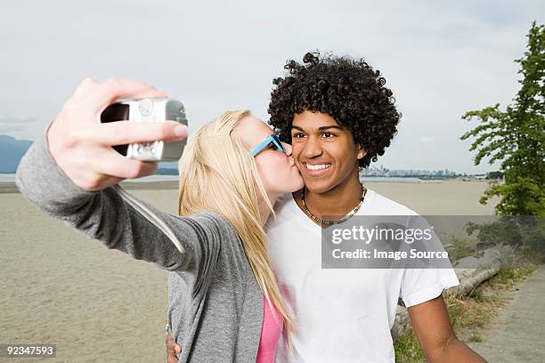 teenage couple with digital camera - black women kissing white men - fotografias e filmes do acervo