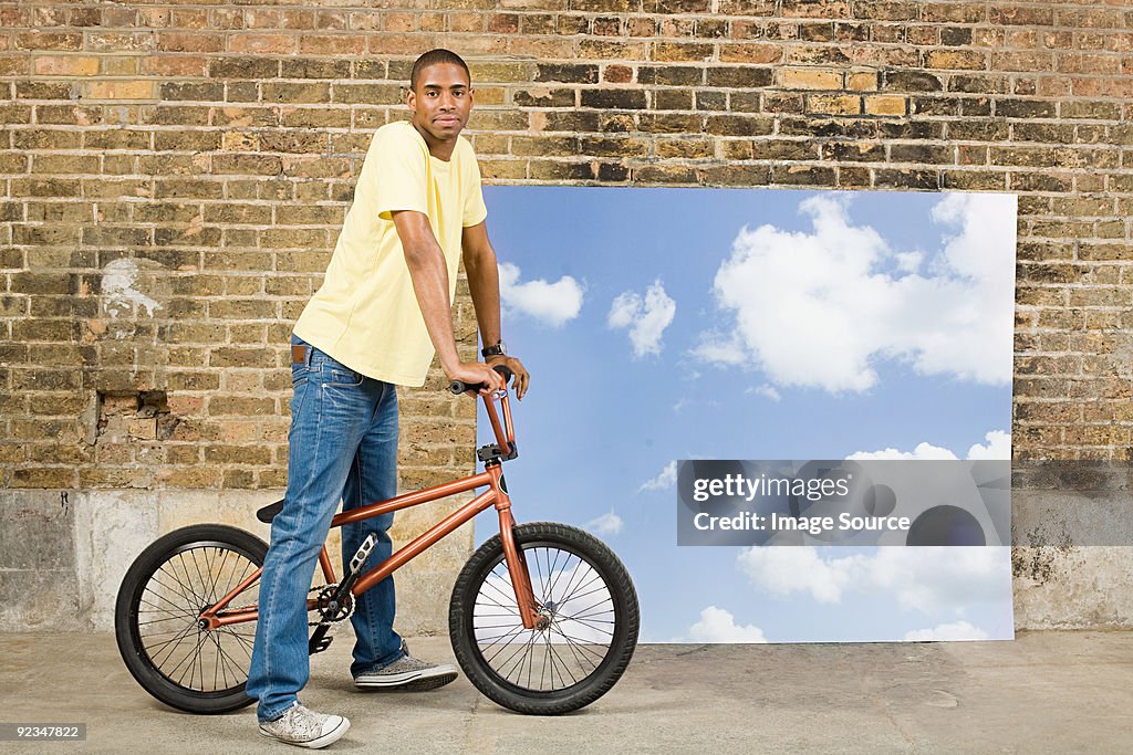 Giovane uomo in bicicletta dal cielo sfondo