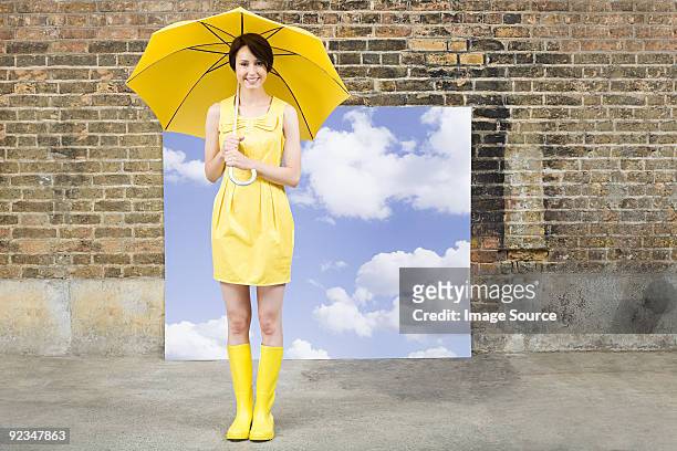 young woman with umbrella and sky background - yellow dress stock pictures, royalty-free photos & images