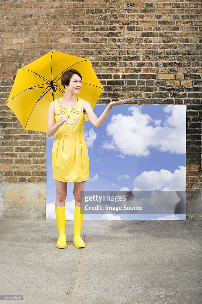Young woman with umbrella and sky background