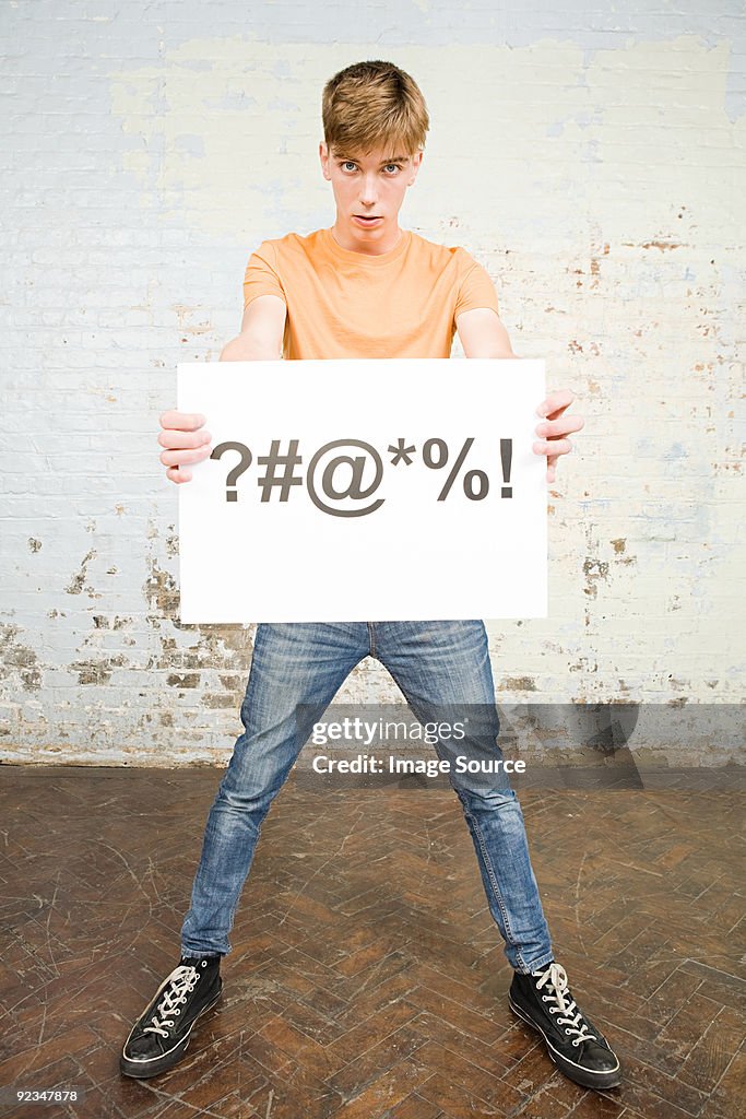 Garoto adolescente segurando placa