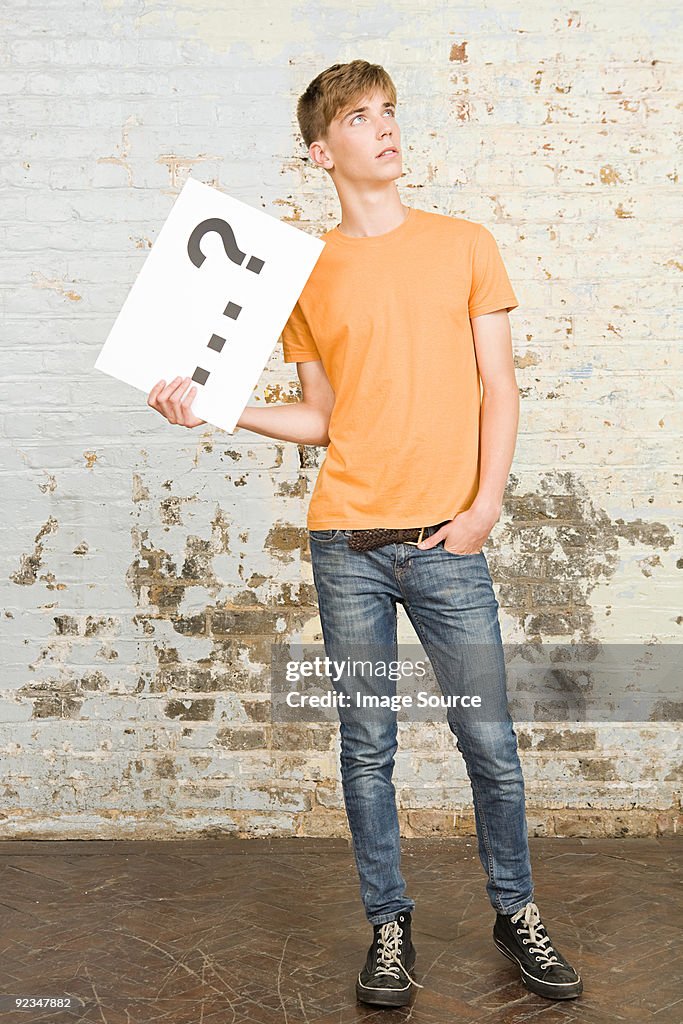 Teenager boy holding sign