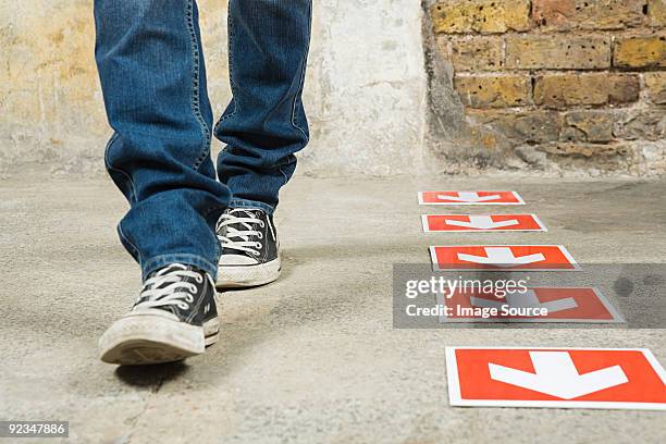 person walking by arrows - red jeans stock pictures, royalty-free photos & images