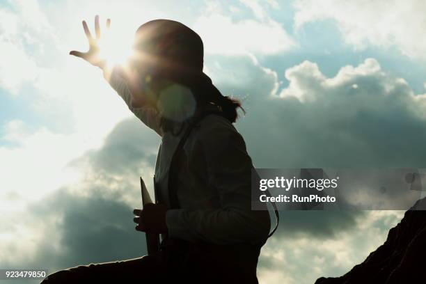 woman reaching hand towards sun - back lit hand stock pictures, royalty-free photos & images