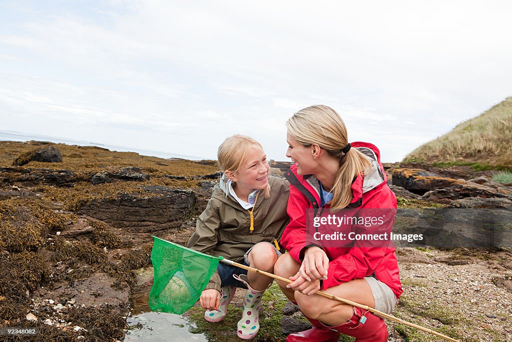 Mother and daughter by rock pools